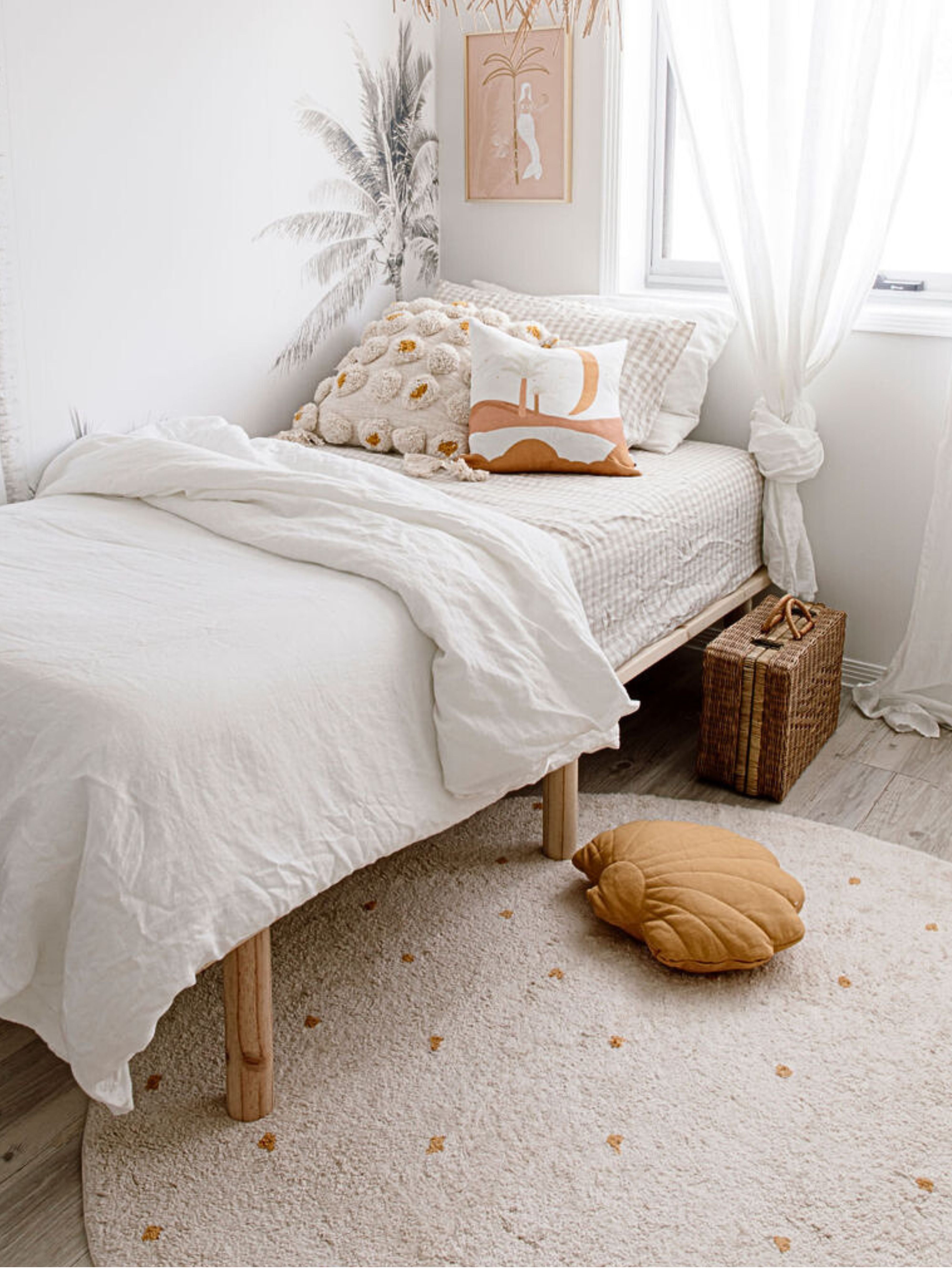 Cozy bedroom with a bed, pillows, and a small rug.