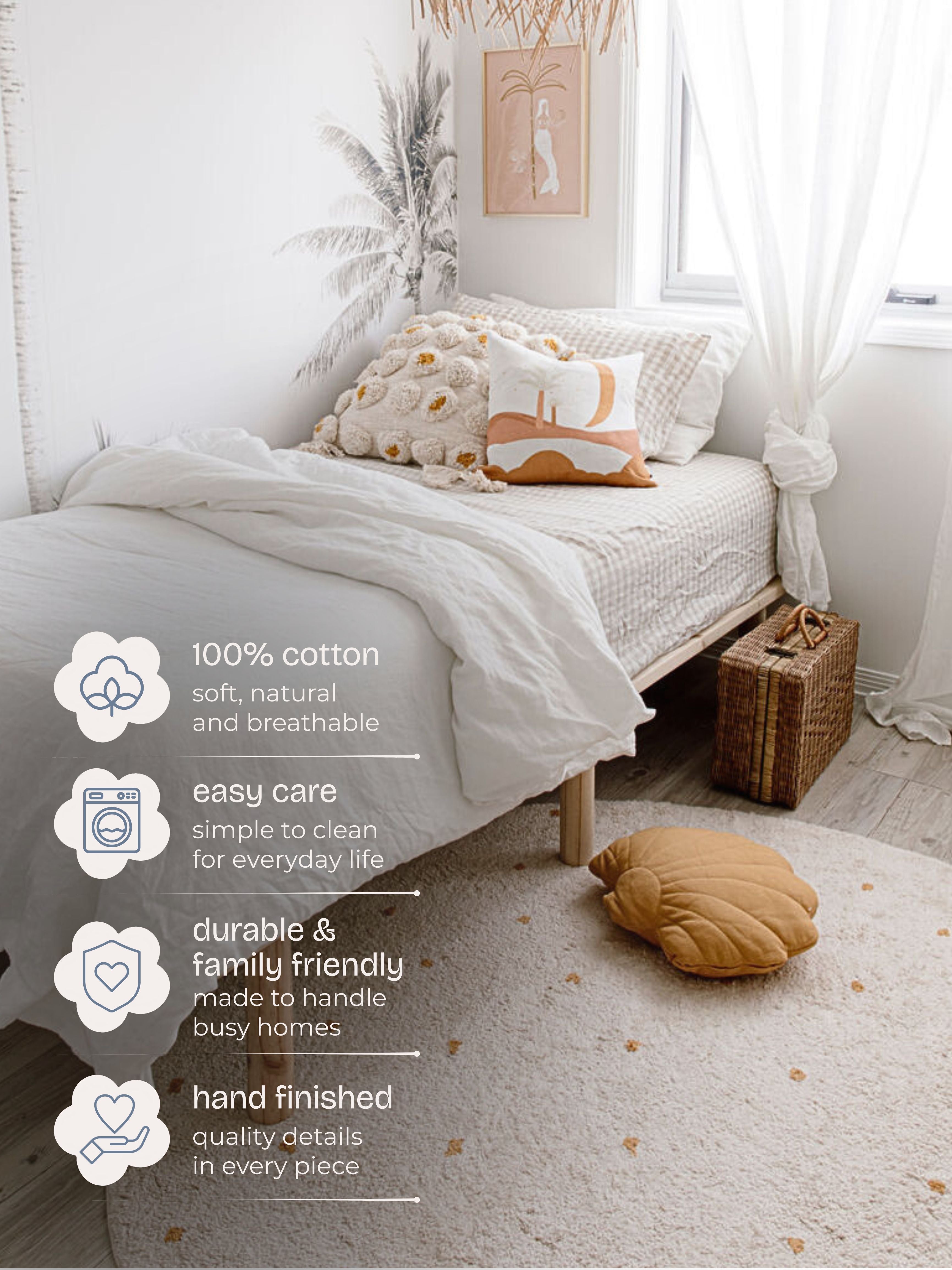 Bedroom with white bedding and decorative pillows, featuring a rug of 100% cotton material.